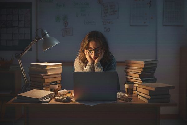 Enseignante fatiguée préparant ses cours le soir